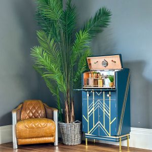 Art Deco cocktail cabinet styled in a living room with palm plant and vintage leather chair